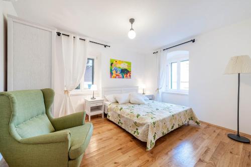 a bedroom with a bed and a chair at Apartments Rialto Gallery in Šibenik