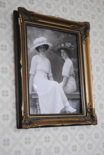 an old photo of two women in hats on a wall at Anfasteröd Gårdsvik - Badstugorna in Ljungskile