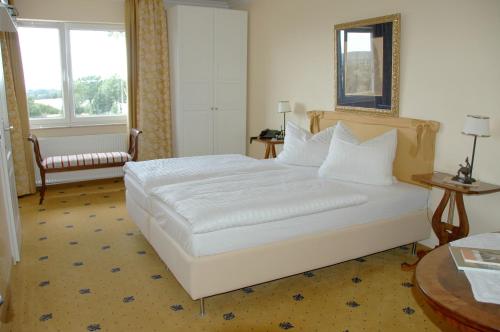 a bedroom with a large white bed in a room at Landsitz Kapellenhöhe, Hotel Garni in Wiedenbrügge