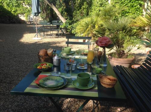 a table with plates of food on it at Maison d'Hôtes Mas de Barbut in Saint-Laurent-dʼAigouze