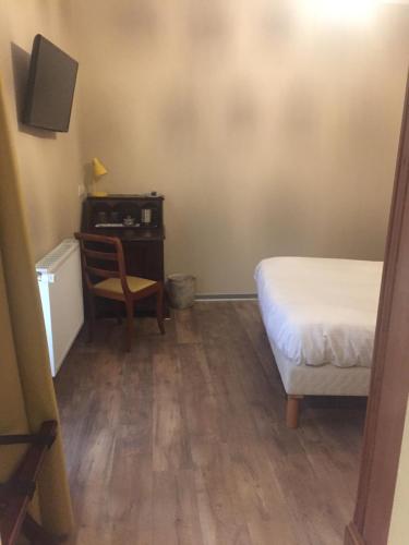 a bedroom with a bed and a desk and a chair at Auberge Le Meisenberg in Châtenois