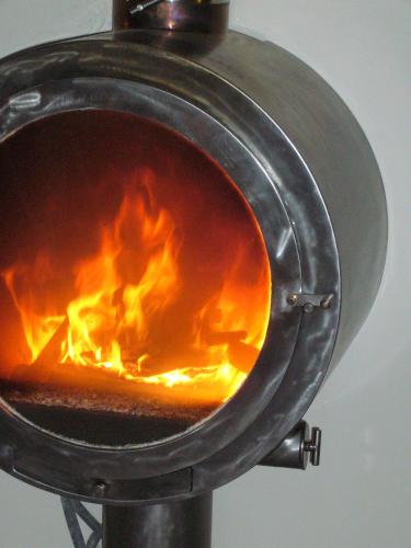 a grill with a fire inside of it at Chambre d'hôtes La Font in Eygliers