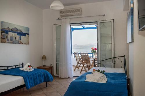 een slaapkamer met 2 bedden en uitzicht op de oceaan bij Pantonia Apartments in Agia Pelagia Kythira