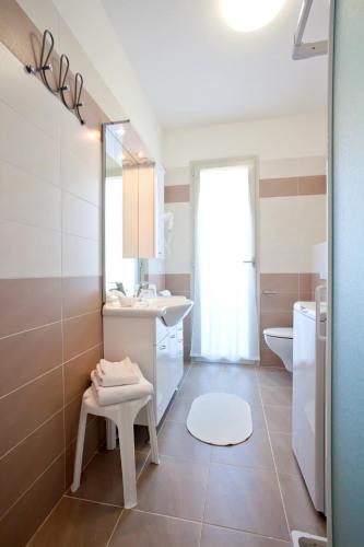 a bathroom with a sink and a toilet and a mirror at Hotel Augusta in Caorle