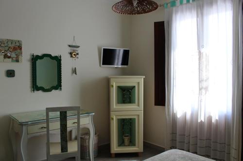 サン・ヴィート・ロ・カーポにあるAzzurromareのテーブル、テレビ、窓が備わる客室です。