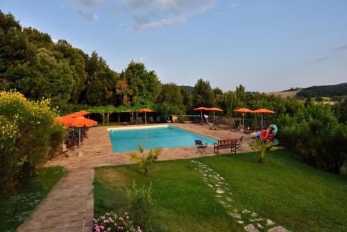 a swimming pool with umbrellas and a yard with a yard at Le Mascie in Sovicille