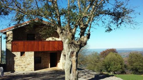 a house with a tree in front of it at Casuca Pico Jiniro in Abionzo