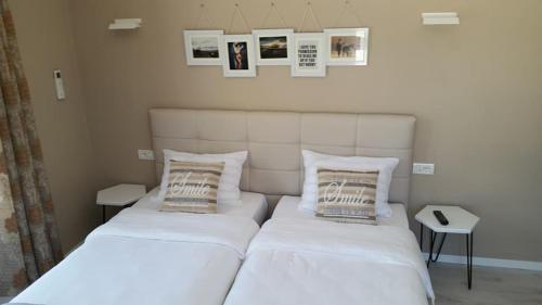 a bed with two pillows and a white comforter at Funky Guest House & Adventures in Përmet