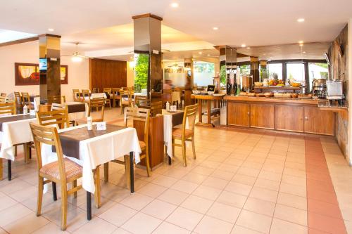 a restaurant with tables and chairs and a kitchen at Hotel Carollo in Mendoza