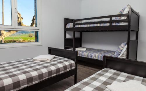 a room with two bunk beds and a window at H.A.N.D Surf Hostel in Langre
