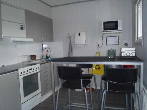 a kitchen with a counter and two bar stools at STF Malmfältens Folkhögskola in Kiruna