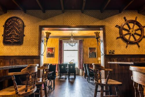 a restaurant with a table and chairs and a steering wheel on the wall at Mount Stewart Hotel in Portpatrick