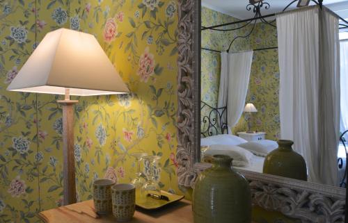 a bedroom with a mirror and a table with a lamp at La Rosa Gialla Bio Apartments & rooms in Barolo