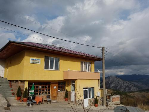 a yellow house with mountains in the background at Guest House Chala in Chala