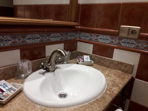 a bathroom sink with aaucet and a white sink at Hospedería Santa Elena in San Carlos del Valle