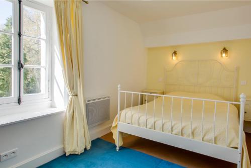 1 dormitorio con cama blanca y ventana en Gite la Brasserie, en Montmorillon