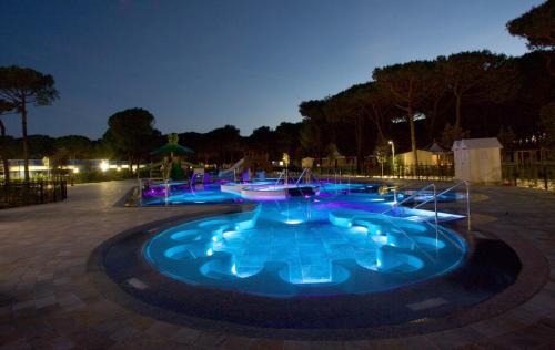 a swimming pool at night with blue lights at Camping Village Cavallino in Cavallino-Treporti