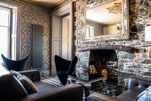 a living room with a stone fireplace and a mirror at Mount Stewart Hotel in Portpatrick