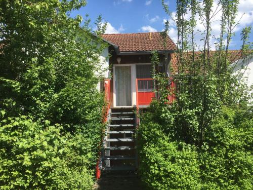 a small red house with stairs leading up to it at Apartmentanlage am Kellerberg in Zandt