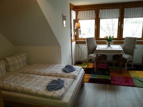 a bedroom with two beds and a table and chairs at Ferienwohnung "Elsnerstrasse" in Nürnberg