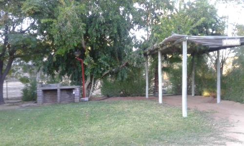 a picnic shelter with a bench in a park at Kalahari Camelthorn Guesthouse and Camping in Askham