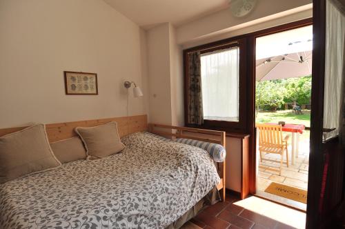 Schlafzimmer mit einem Bett und einer Tür zu einer Terrasse in der Unterkunft Alla Cantina in Aurisina Case