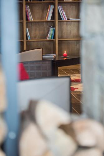 Cette chambre dispose d'un bureau et d'étagères avec des livres. dans l'établissement CGH Résidences & Spas Chalet Les Marmottons, à La Rosière