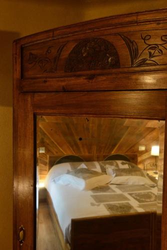 a large wooden bed with a wooden head board at Vecchio Mulino Guest House in Aosta