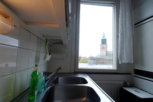a kitchen counter with two sinks and a window at Cozy Apartment near Turku Cathedral Church in Turku