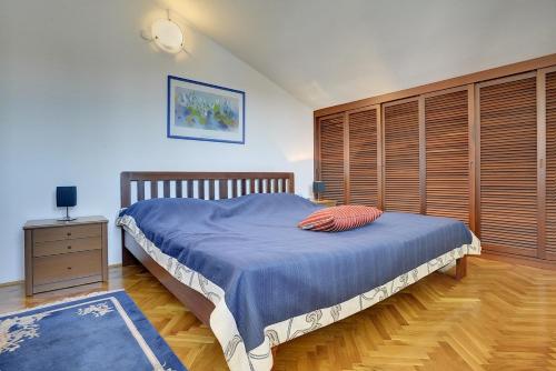 sypialnia z dużym łóżkiem i drewnianą ścianą w obiekcie Holiday Home Lorena w mieście Premantura