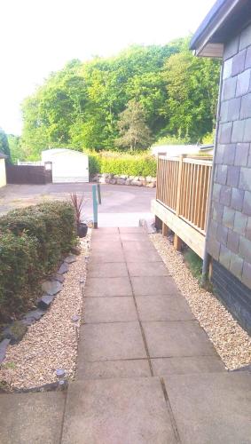 a sidewalk in front of a house with a bench at 147 Snowdon Drive, Glan Gwna in Caernarfon