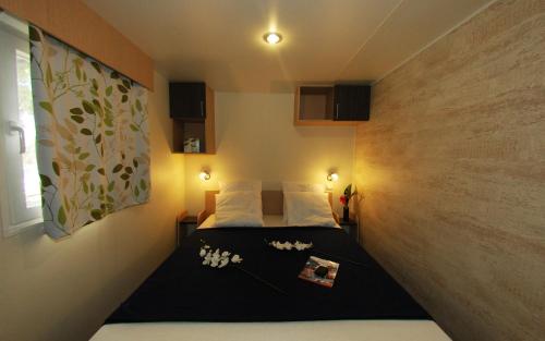 a small bedroom with a bed in a room at Camping de la Treille in Cavalaire-sur-Mer