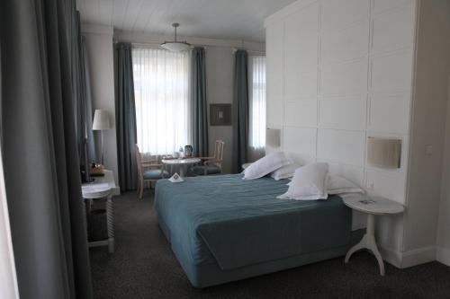 Kar's Hotel في كارس: غرفة نوم بسرير ازرق وطاولة