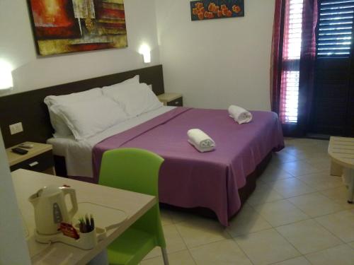 Habitación de hotel con cama con manta morada en La Locanda Del Mare B&B, en La Caletta