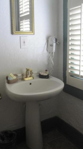 a white sink in a bathroom with a mirror at St. Francis Inn - Saint Augustine in Saint Augustine