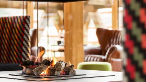 a fireplace on a table with teddy bears on it at Relais & Châteaux Gut Steinbach Hotel Chalets SPA in Reit im Winkl