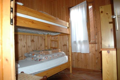 una camera con 2 letti a castello e una finestra di Camping Camplani a Zone