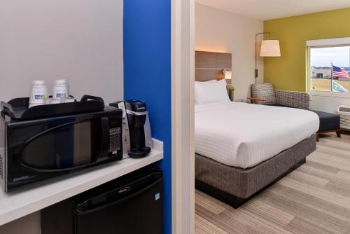 セント・ピーターズバーグにあるHoliday Inn Express & Suites - St. Petersburg - Madeira Beach by IHGのベッドと電子レンジ付きのホテルルーム