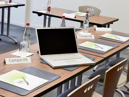 a table with a laptop computer on top of it at Campanile Rouen Nord - Mont-Saint-Aignan in Mont-Saint-Aignan