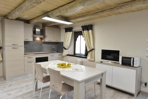 a white kitchen with a white table and chairs at Vecchio Mulino Guest House in Aosta