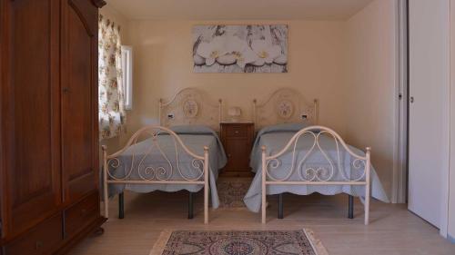 ルッカにあるLa Locanda Francigenaのベッドルーム1室(ベッド2台、テーブル、椅子2脚付)