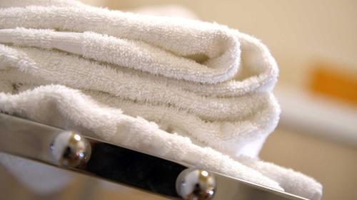 Una pila de toallas blancas encima de un cuchillo. en La Locanda Francigena, en Lucca