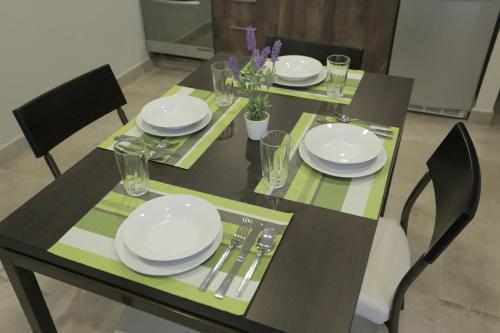 a dining table with plates and utensils on it at Links Apart Hotel in Río Grande