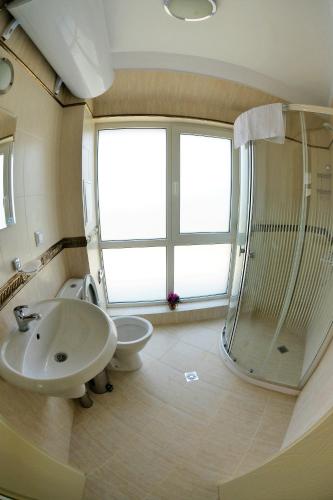a bathroom with a sink and a toilet and a shower at Zevs Residence in Nesebar