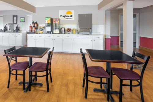 two tables and chairs in a room with a kitchen at Days Inn by Wyndham College Station University Drive in College Station