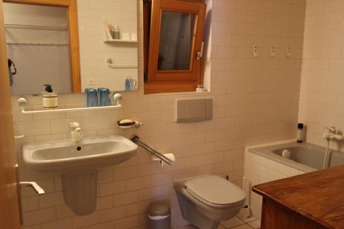 ein Badezimmer mit einem Waschbecken, einem WC und einer Badewanne in der Unterkunft La Boutique in Rossinière