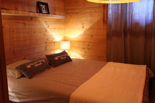 sypialnia z łóżkiem z 2 poduszkami i lampką w obiekcie La Boutique w mieście Rossinière