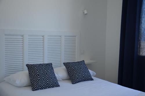 a bed with two pillows sitting on top of it at Hotel La Casa in Le Barcarès