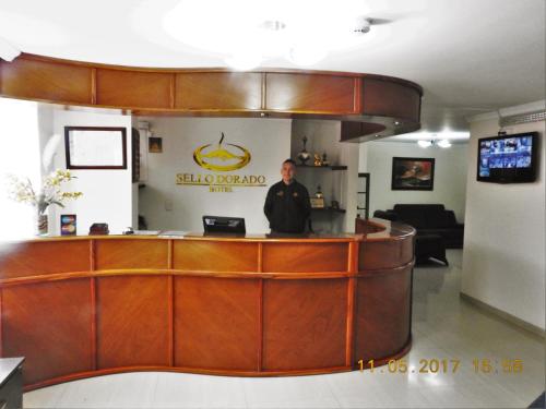 Ein Mann, der am Tresen eines Salons steht. in der Unterkunft Hotel Sello Dorado in Pasto