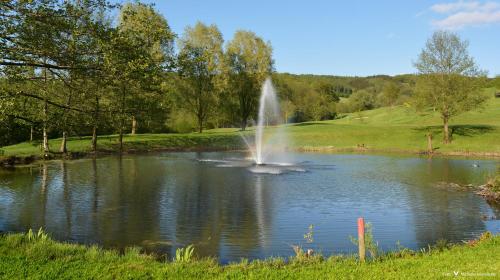 a fountain in the middle of a pond at Golf Hotel Mergelhof in Gemmenich